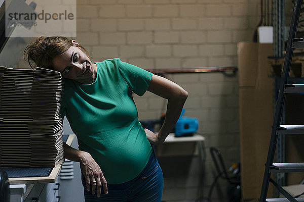 Überwältigte schwangere Frau zieht im Bürokeller komische Gesichter