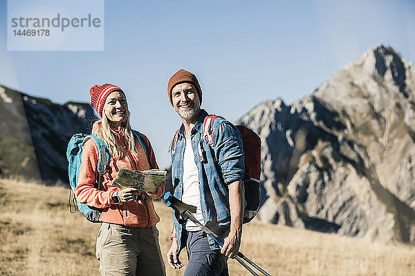 Österreich  Tirol  glückliches Paar mit Karte auf einer Wanderung in den Bergen
