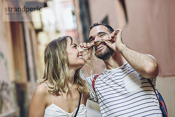 Spanien  Andalusien  Malaga  Komiker  der die Haare seiner Freundin als Schnurrbart verwendet
