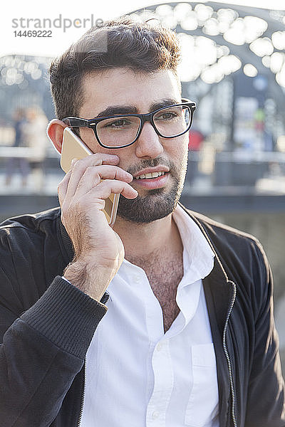 Deutschland  München  Porträt eines jungen Geschäftsmannes am Telefon am zentralen Busbahnhof
