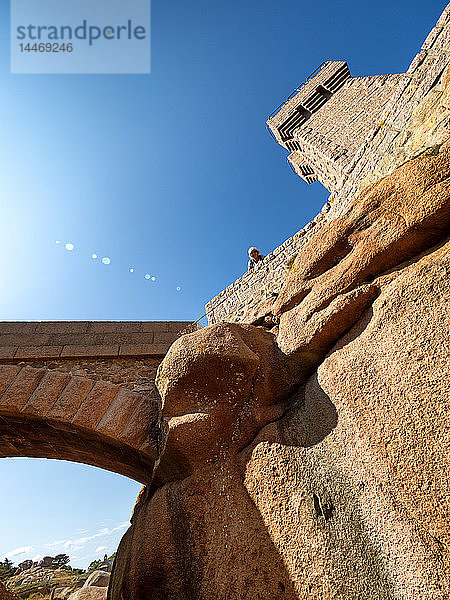 Frankreich  Bretagne  Côte de Granit Rose  ältere Frau  die auf Phare de Mean Ruz herunterblickt