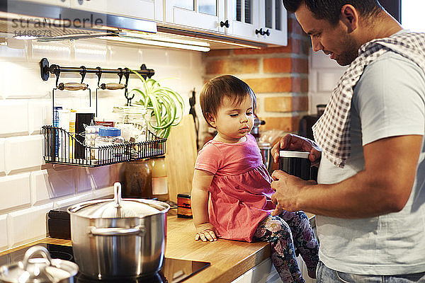 Vater und kleines Mädchen kochen gemeinsam zu Hause in der Küche