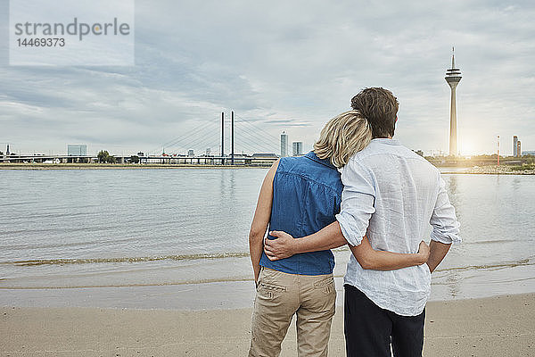 Deutschland  Düsseldorf  liebevolles junges Paar am Rheinufer