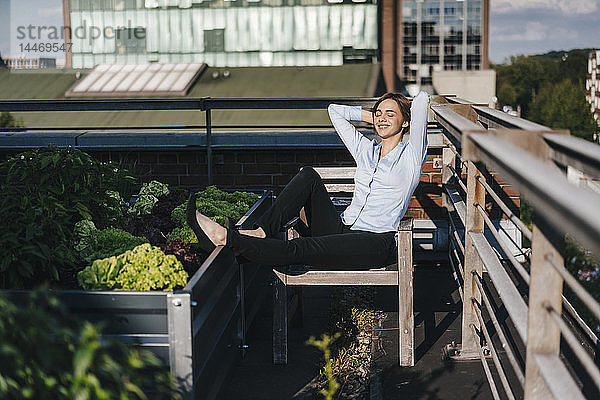 Geschäftsfrau entspannt sich in seinem städtischen Dachgarten