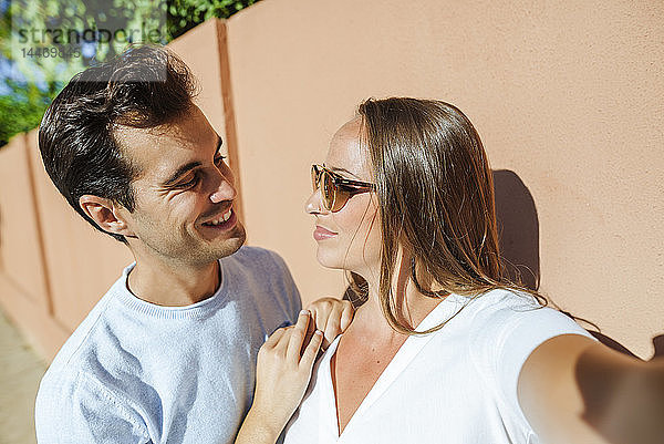 Selfie eines lächelnden Paares  das sich an einem sonnigen Tag anschaut