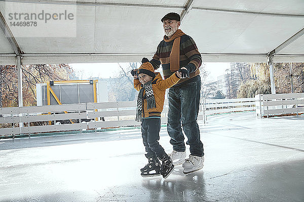 Grossvater und Enkel auf der Eisbahn  Schlittschuhlaufen