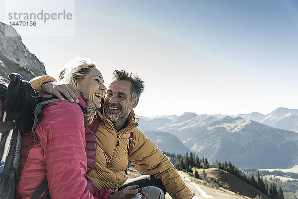 Österreich  Tirol  glückliches Paar macht Pause während einer Wanderung in den Bergen