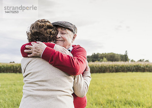 Älteres Ehepaar umarmt sich in ländlicher Landschaft