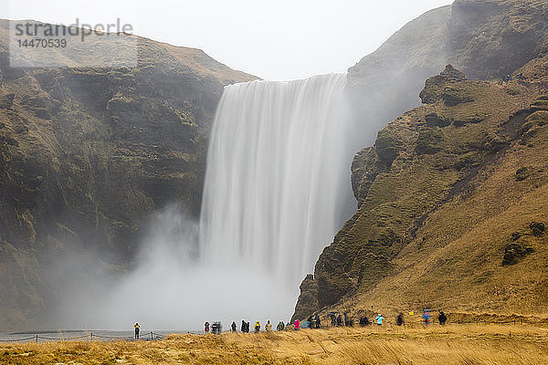 Island  Touristen am Skogafoss-Wasserfall