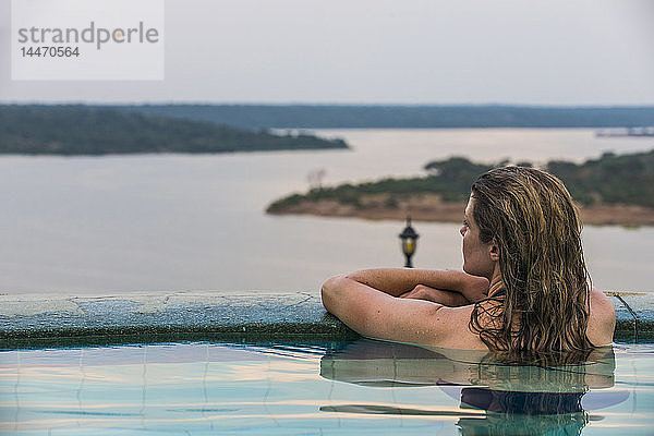 Afrika  Uganda  Queen-Elizabeth-Nationalpark  Frau entspannt sich in einem Pool über dem Kazinga-Kanal