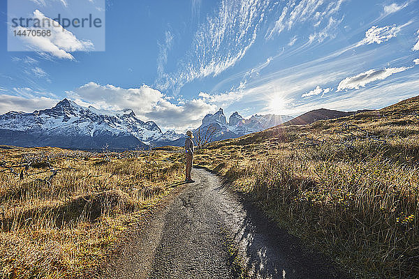 Chile  Torres del Paine Nationalpark  Frau steht bei Sonnenaufgang vor dem Torres del Paine Massiv