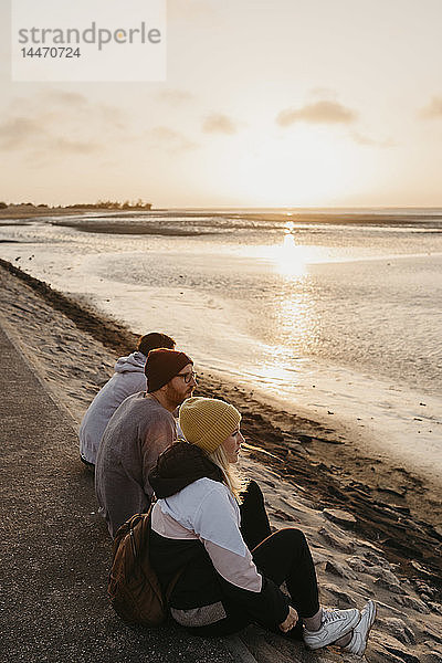 Namibia  Walvis Bay  drei Freunde entspannen sich bei Sonnenuntergang