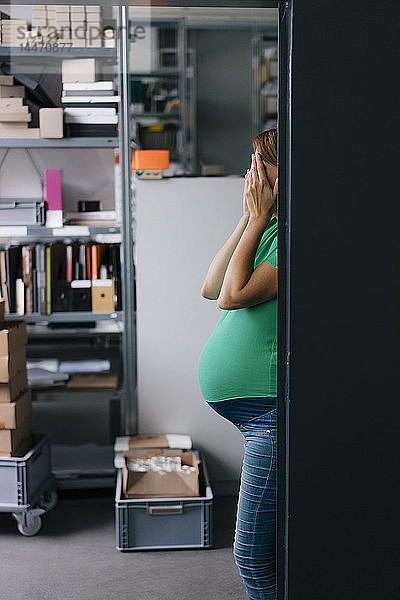 Schwangere Frau versteckt ihr Gesicht im Amt