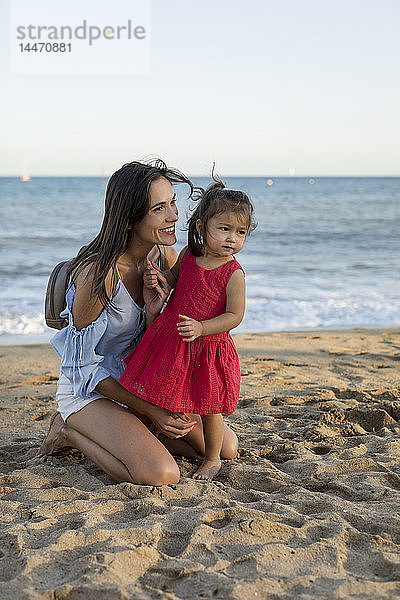 Mutter und Tochter spielen am Strand