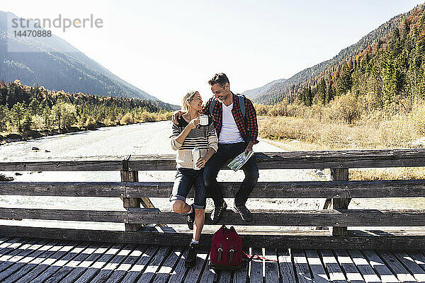 Österreich  Alpen  Ehepaar auf einer Wanderung mit Rast auf einer Brücke