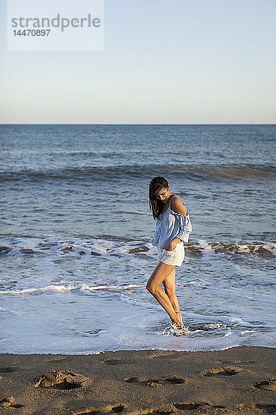 Porträt einer schönen Frau am Strand  im Wasser stehend