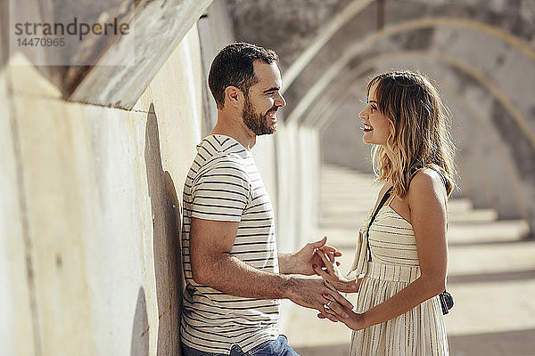 Spanien  Andalusien  Malaga  glückliches  liebevolles Touristenpaar unter einem Torbogen in der Stadt