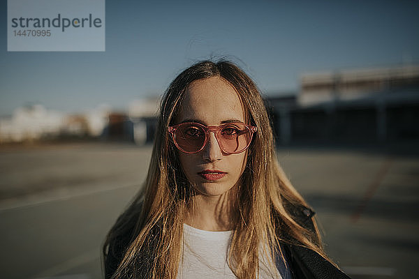 Porträt einer jungen Frau mit Sonnenbrille im Freien