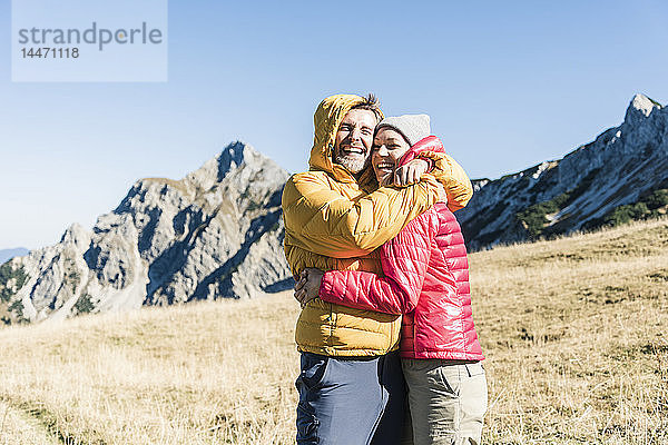 Österreich  Tirol  glückliches Paar umarmt sich bei einer Wanderung in den Bergen