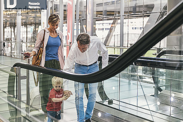 Familie auf der Rolltreppe am Flughafen