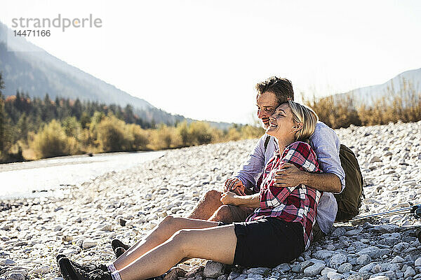 Österreich  Alpen  glückliches Paar auf Wanderung mit Rast an einem Bach