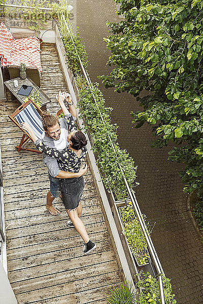 Junges  liebevolles Paar tanzt auf ihrem Balkon