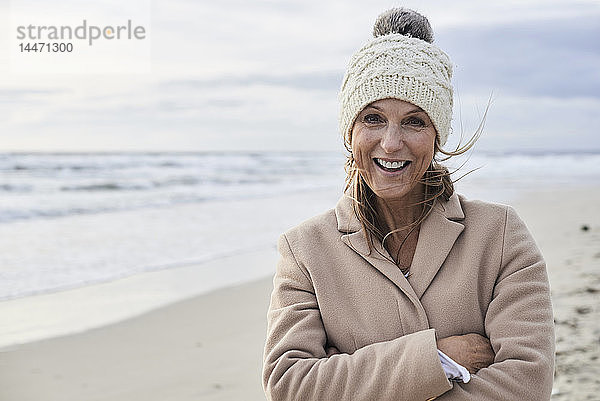 Spanien  Menorca  Porträt einer glücklichen älteren Frau am Strand im Winter