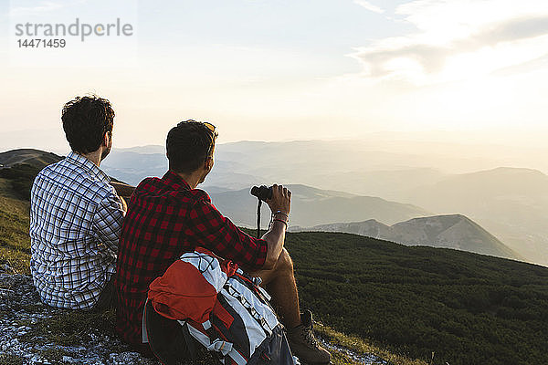 Italien  Monte Nerone  zwei Wanderer auf dem Gipfel eines Berges  die bei Sonnenuntergang die Aussicht geniessen