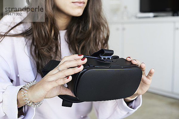 Gesichtslose Frau hält Virtual-Reality-Headsets zu Hause