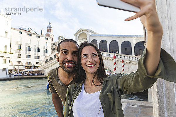 Italien  Venedig  ein Paar  das die Stadt genießt und ein Selfie mit der Rialto-Brücke im Hintergrund