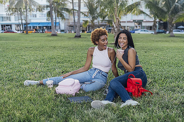 Zwei glückliche Freundinnen entspannen sich in einem Park