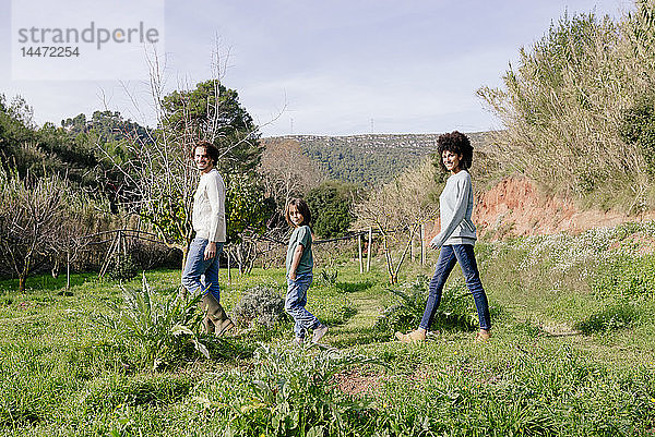 Glückliche Familie beim Spaziergang auf dem Land  in einer Reihe