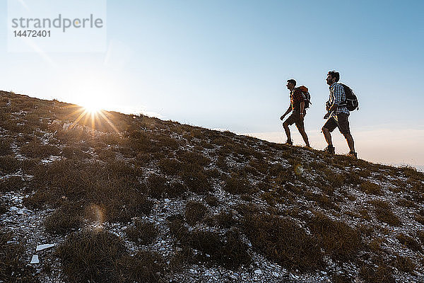 Italien  Monte Nerone  zwei Männer wandern in den Bergen bei Sonnenuntergang