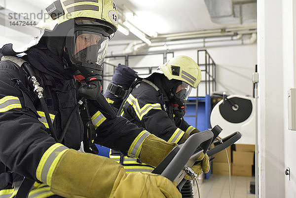 Zwei Feuerwehrleute mit Atemschutzgerät und Luftbehälter beim Training auf dem Laufband