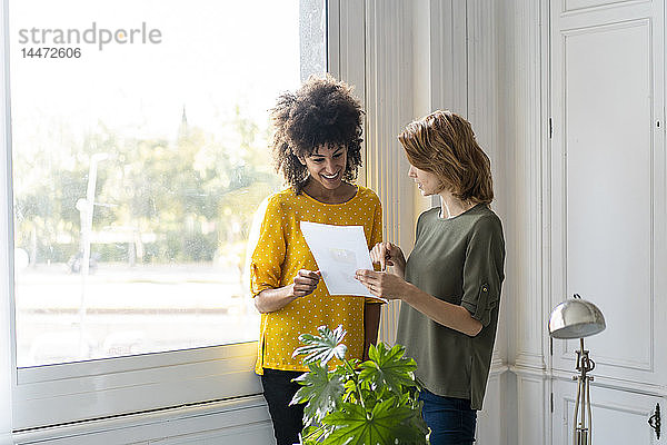 Kollegen im Coworking Space diskutieren über Geschäftslösungen