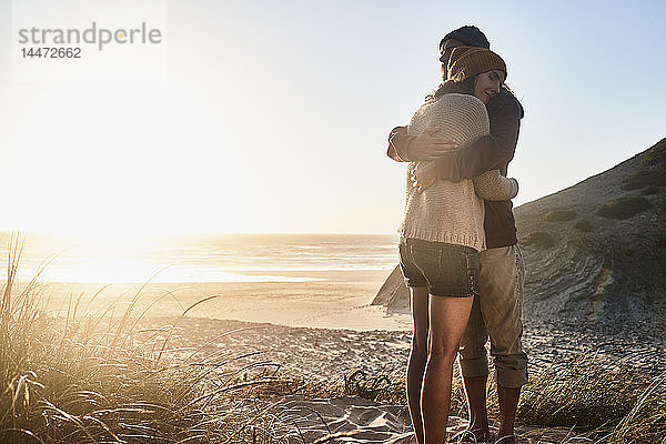 Portugal  Algarve  Paar umarmt sich bei Sonnenuntergang am Strand