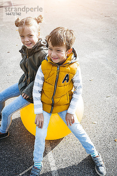 Porträt von zwei Kindern  die sich mit dem Gymnastikball amüsieren