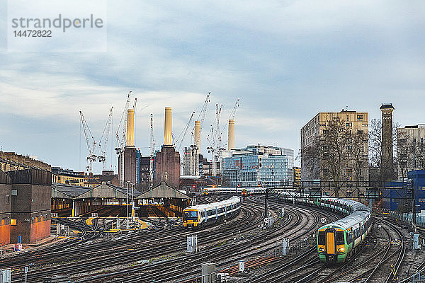Vereinigtes Königreich  England  London  Blick auf Eisenbahnschienen und Züge am Abend  im Hintergrund das ehemalige Battersea-Kraftwerk und Kräne