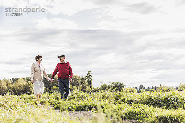 Älteres Ehepaar bei einem Spaziergang in ländlicher Landschaft