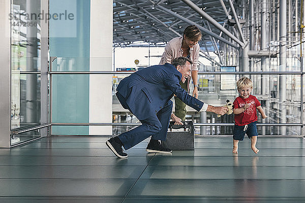 Glückliches Kind rennt als Geschäftsreisender auf dem Flughafen herum