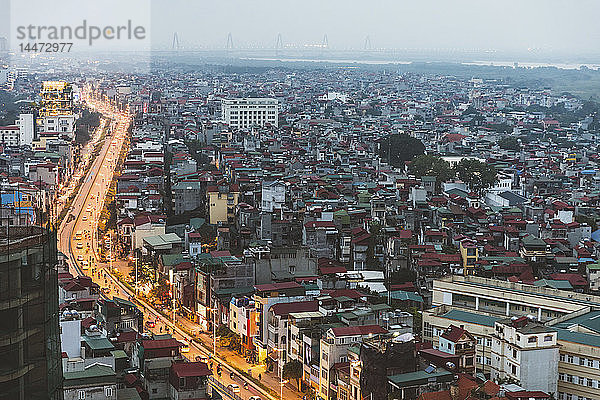 Vietnam  Hanoi  Panoramablick auf die Stadt in der Dämmerung  mit beleuchteter Hauptstraße und dunklen Wohngebieten