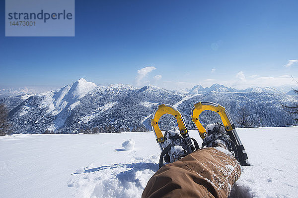 Österreich  Bundesland Salzburg  Altenmarkt-Zauchensee  Mann mit Schneeschuhen im Tiefschnee liegend