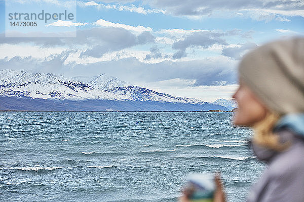 Argentinien  Lago Posadas  Frau hält Becher am Seeufer