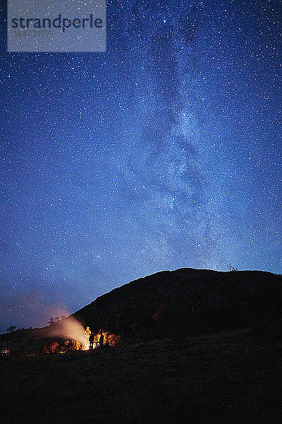 Chile  Feuerland  Lago Blanco  Menschen am Lagerfeuer unter nächtlichem Sternenhimmel