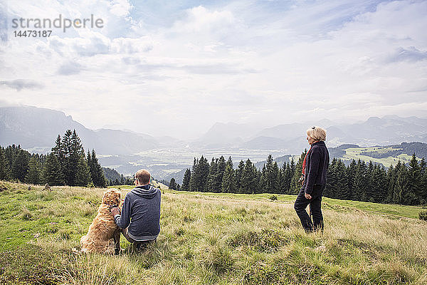 Österreich  Tirol  Kaisergebirge  Mutter und erwachsener Sohn mit Hund auf einer Wanderung in den Bergen