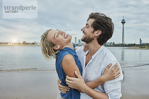 Deutschland  Düsseldorf  glückliches junges Paar am Rheinufer