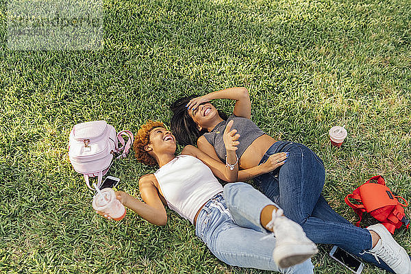 Zwei unbekümmerte Freundinnen entspannen sich in einem Park