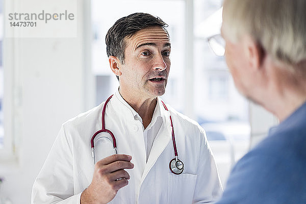 Porträt eines Arztes und Gespräch mit einem Patienten in der medizinischen Praxis