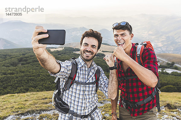 Italien  Monte Nerone  zwei glückliche Wanderer auf dem Gipfel eines Berges  die ein Selfie