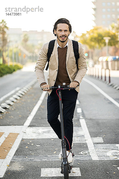 Porträt eines Mannes  der einen E-Scooter in der Stadt benutzt